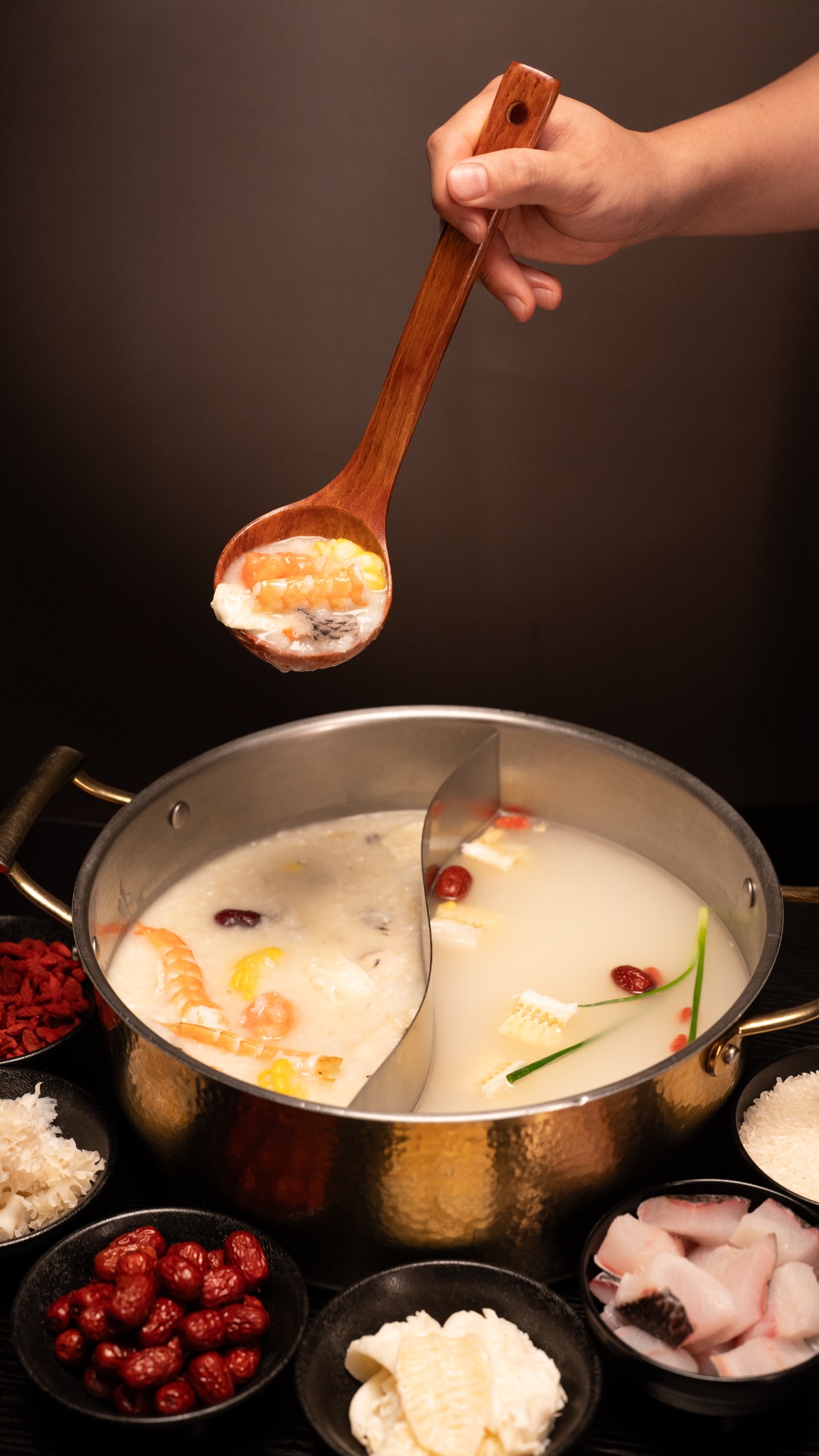 木勺舀起鲜鱼粥,锅中一半鱼汤一半粥